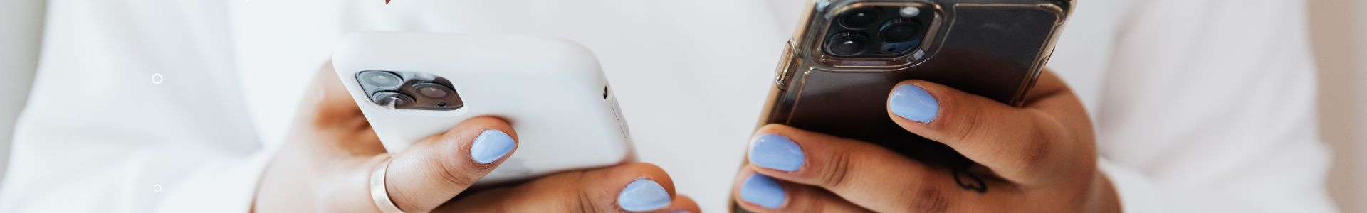 Pessoa usando dois celulares com ícones de mensagens e curtidas, simbolizando interação em redes sociais no contexto profissional.